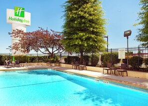 A Holiday Inn pool area with a sign, chairs, and a fence. - Holiday Inn Little Rock-Presidential-Dwntn by IHG (Little Rock)