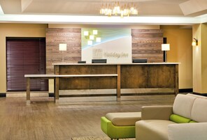 Un mostrador de recepción con un fondo de madera, un candelabro y un letrero que dice 'Holiday Inn'.