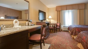 A hotel room with a bed, a desk, a chair, a television, and a bathroom. - Castle Inn and Suites (Anaheim)