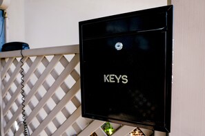A black metal box with the word "KEYS" on it, attached to a white lattice structure.