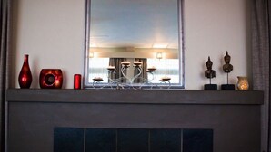 A fireplace mantel with decorative items and a large mirror above it. - Abbotsleigh Motor Inn (Armidale)