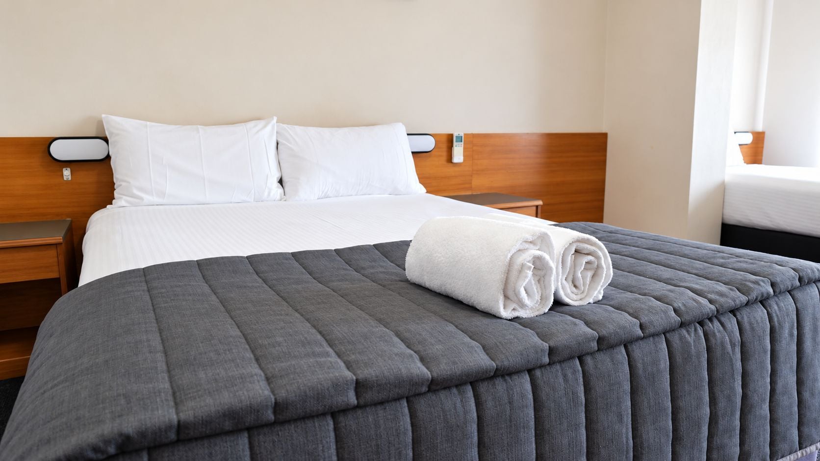 Habitació d'hotel amb llit, una taula de nit i una finestra.