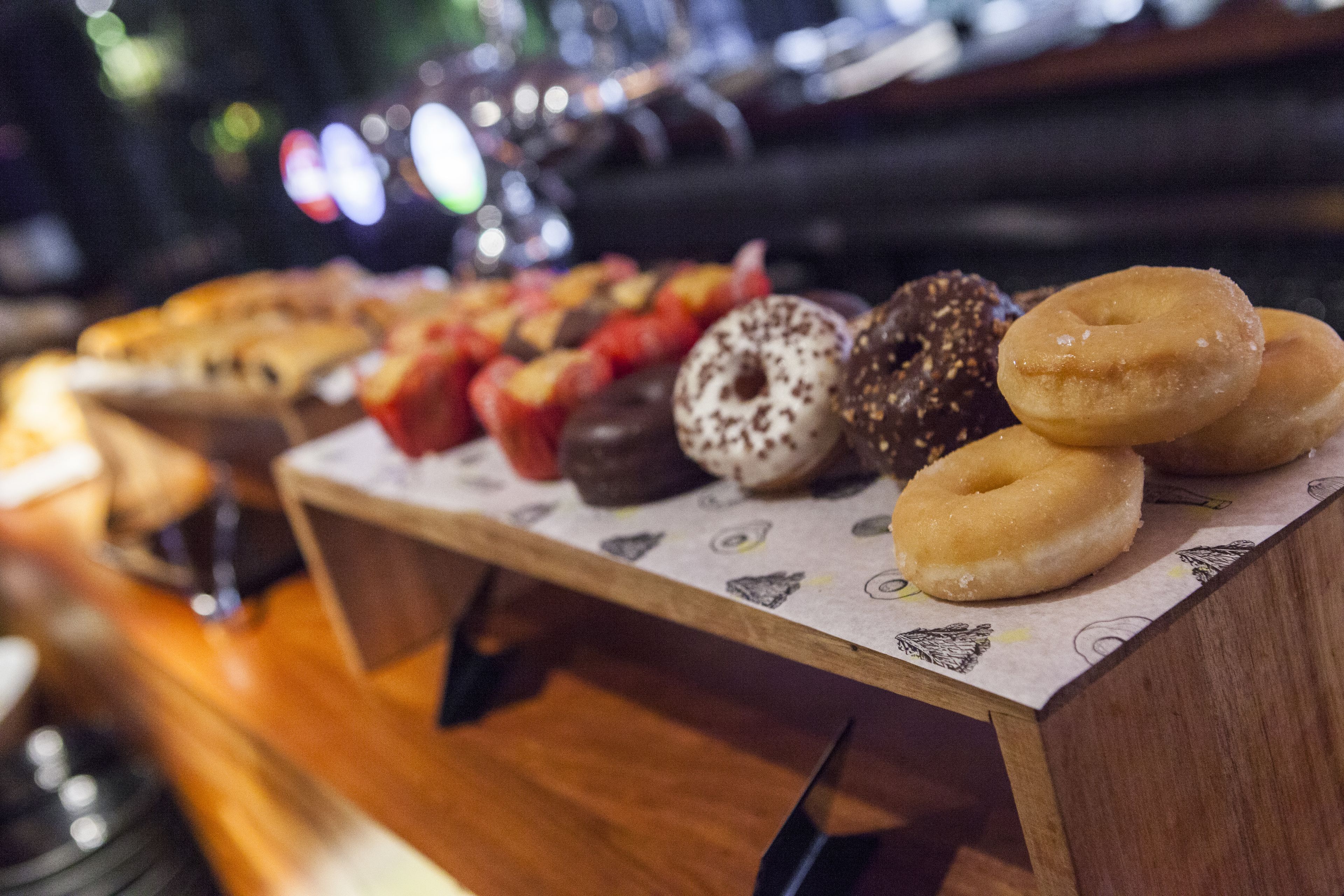 Variedad de donas sobre una encimera de madera.