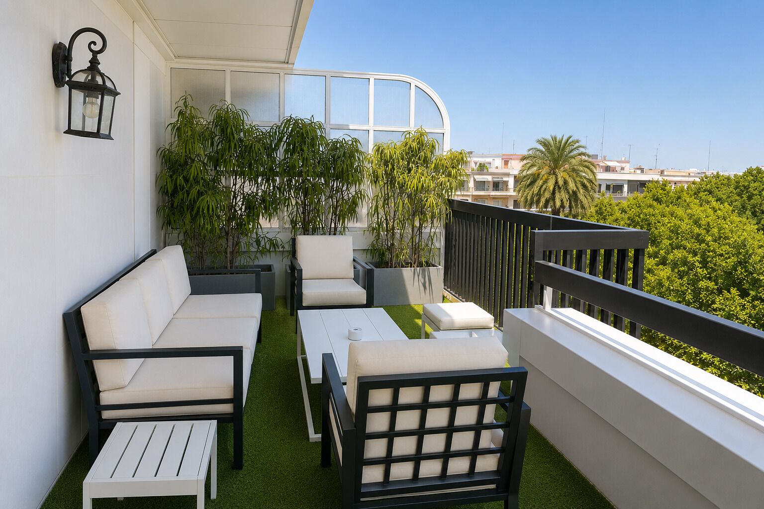 A balcony with a sofa, chairs, a table, and potted plants.