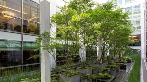 A modern building with large windows, indoor plants, and a view of the sky. - La Clef Tour Eiffel Paris by The Crest Collection (Paris)