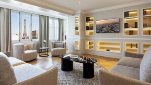 A modern living room with a view of the Eiffel Tower, a black coffee table, and built-in shelves with decorative items. - La Clef Tour Eiffel Paris by The Crest Collection (Paris)