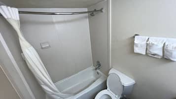 Un baño con ducha, inodoro y toallero.
