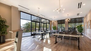 A modern conference room with large windows, wooden flooring, and contemporary furniture. - Home2Suites by Hilton Anaheim Resort (Anaheim)