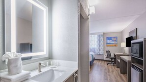 Ein modernes Badezimmer mit einem großen Spiegel, zwei Waschbecken und einem Handtuchhalter.