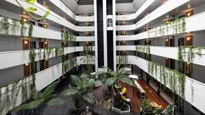 A multi-level atrium with indoor plants, seating areas, and a central staircase. - Novotel Darwin CBD (Darwin)