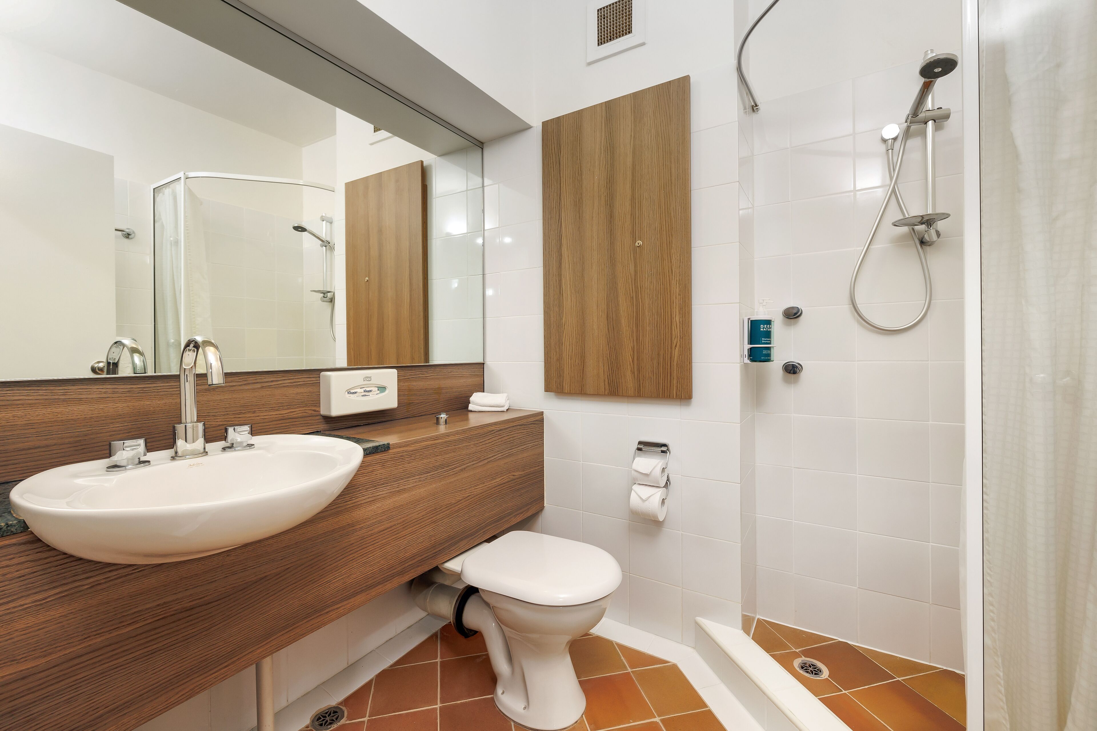 A modern bathroom with a sink, toilet, and shower.
