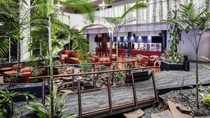 A multi-level indoor space with seating areas, a bar, and various plants. - Novotel Darwin CBD (Darwin)