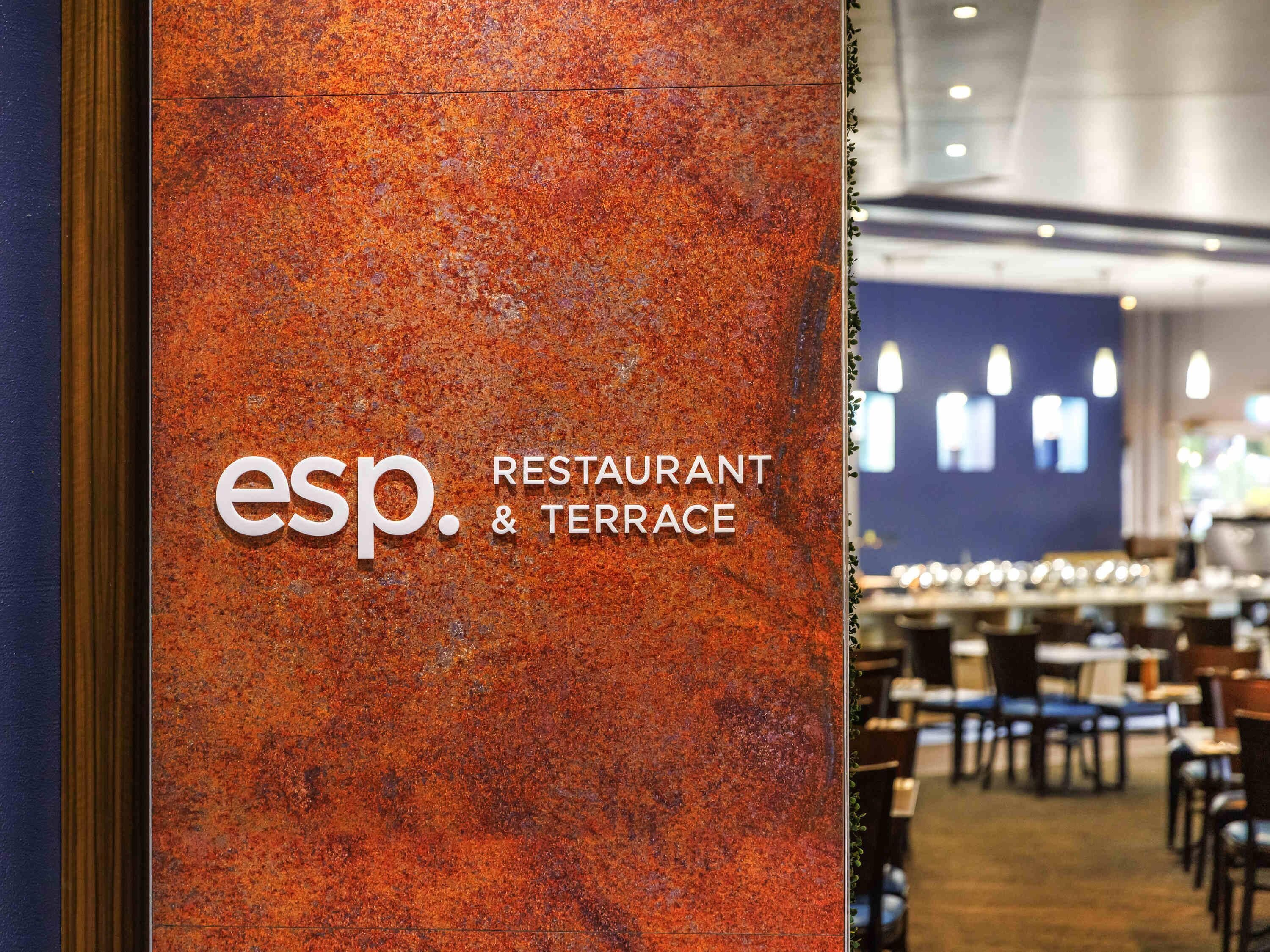A restaurant sign with 'esp. RESTAURANT & TERRACE' on a textured orange wall.