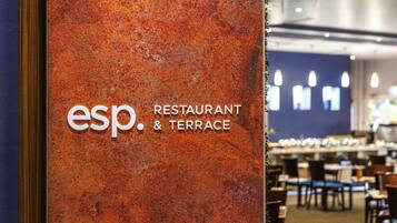 A restaurant sign with 'esp. RESTAURANT & TERRACE' on a textured orange wall.