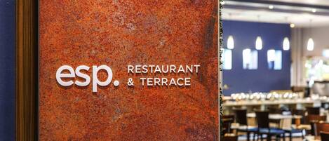 A restaurant sign with 'esp. RESTAURANT & TERRACE' on a textured orange wall.