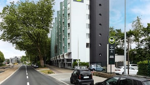 A B&B hotel with a modern design, featuring a prominent cylindrical tower and a flat facade with multiple windows.