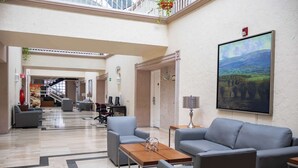 A spacious lobby with a high ceiling, a large painting on the wall, and a seating area with sofas and a coffee table. - Best Western Plus Monterrey Colon (Monterrey)