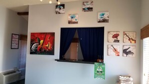 A hotel lobby with a window, artwork on the walls, and a sign for a March event. - The Parkwood Inn & Suites (Mountain View)