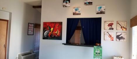 A hotel lobby with a window, artwork on the walls, and a sign for a March event.