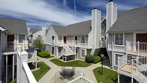 Stunning courtyard with seating area and fire pit, surrounded by balconies and windows offering views of the surrounding area.