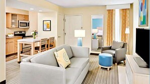A hotel room with a living area, kitchenette, and a television. - Sonesta ES Suites Cincinnati - Sharonville West (Sharonville)