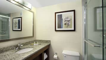 Une salle de bain avec un lavabo en granit, des toilettes et un tableau encadré au mur.