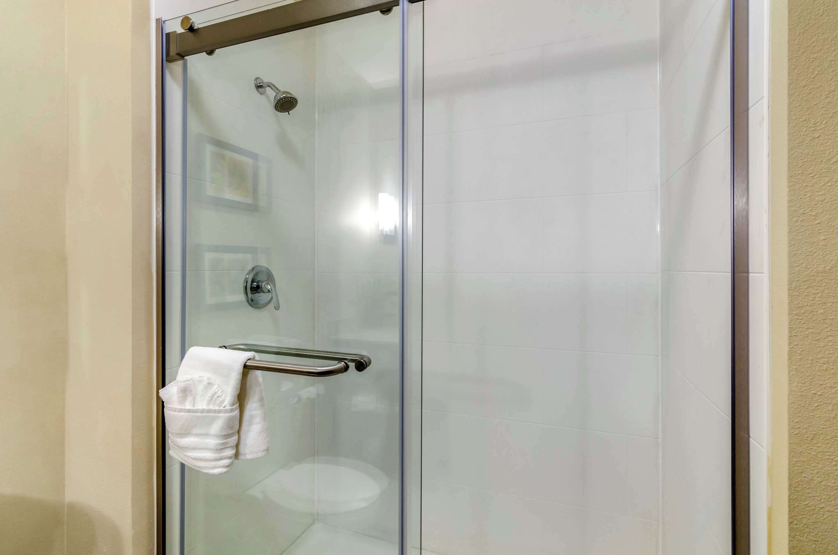 A glass-enclosed shower with a towel rack and a glass door.