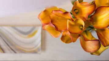 A close-up of orange calla lilies in a vase.