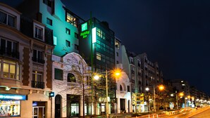 A hotel with a modern facade, multiple floors, and illuminated signage.