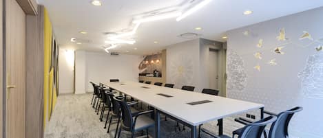 A conference room with a long table, chairs, and a modern ceiling design.