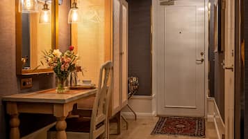 Une chambre à coucher avec un lit, un bureau et une chaise, un miroir et une porte.