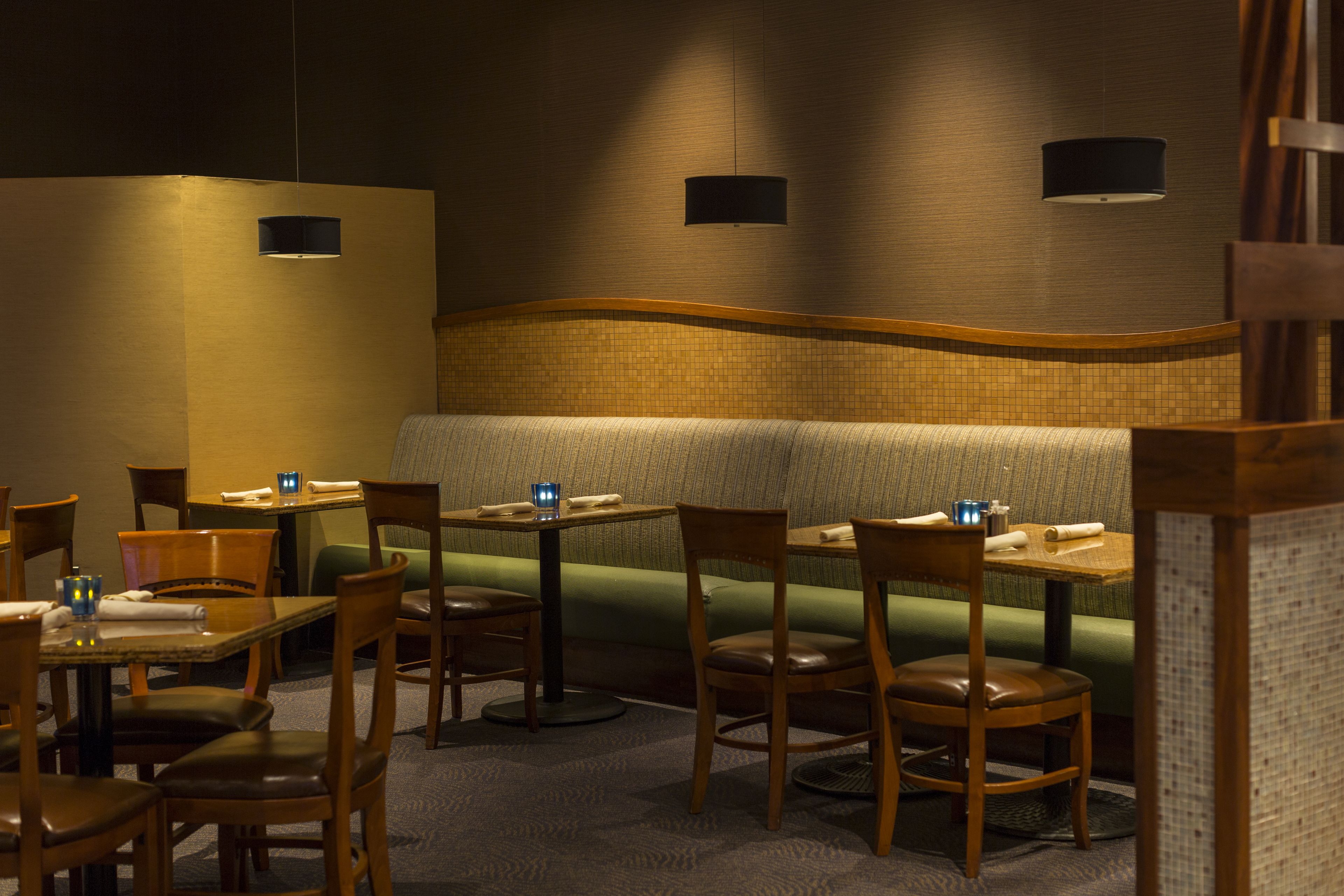 Een restaurantinterieur met zitjes, tafels en stoelen.
