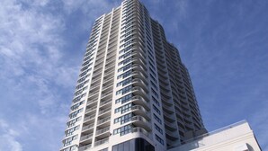 Un edificio moderno y alto con varios balcones y ventanas amplias.