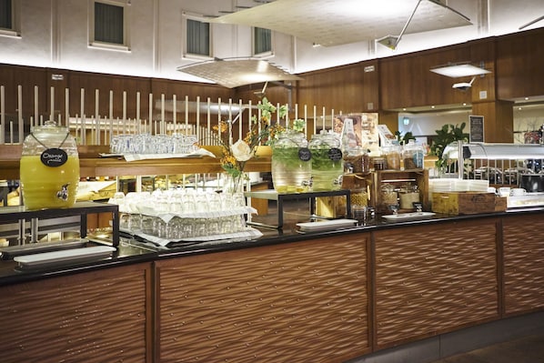 Un'area buffet con diversi cibi e distributori di bevande.