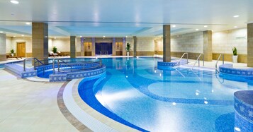 Una piscina techada, sillones reclinables de piscina