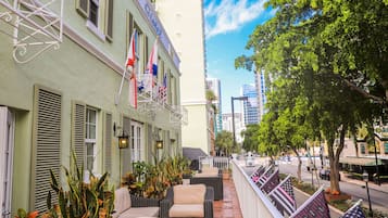 Ett hotell med uteservering, amerikanska flaggor och utsikt över staden.