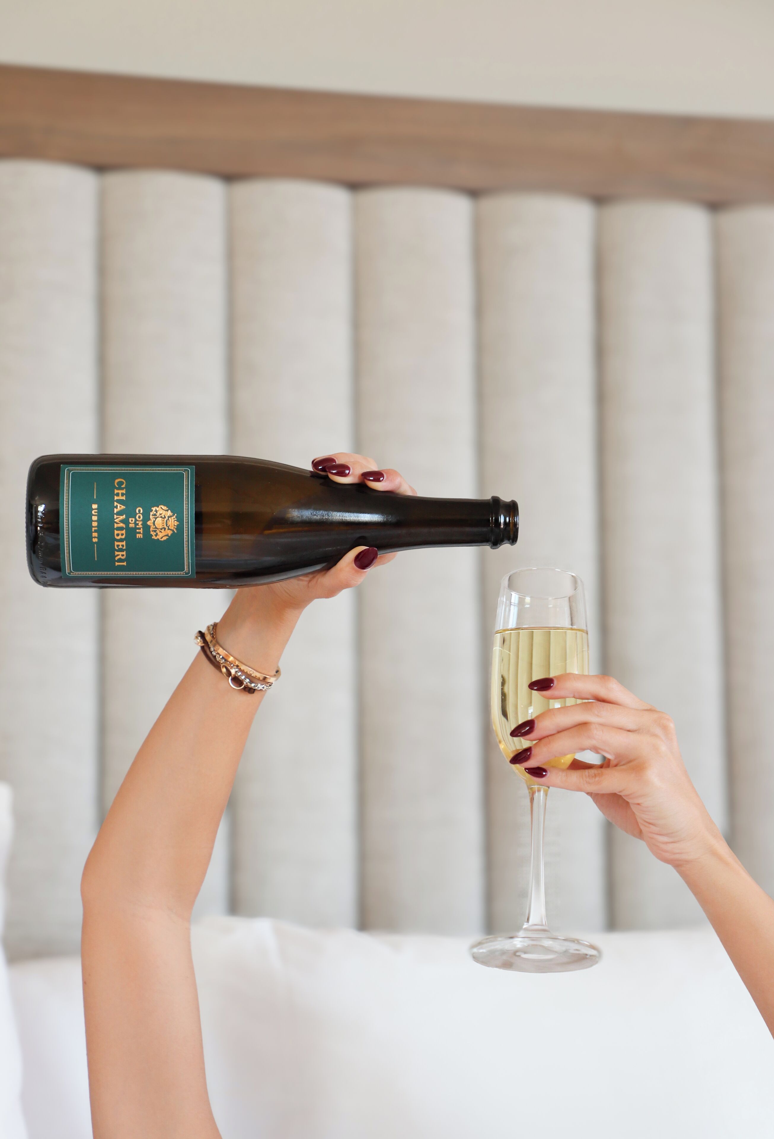 Eine Person gießt Champagner aus einer Flasche in ein Glas.