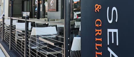 Zona de estar al aire libre con un letrero que dice 'Wild Sea Oyster Bar & Grille'.