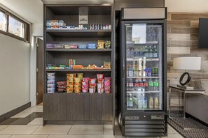 A vending machine and a refrigerated display case stocked with snacks and beverages in a commercial setting. - Best Western At O'Hare (Rosemont)