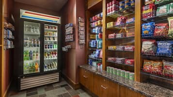 A snack aisle with various packaged goods and a refrigerated display.