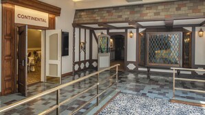 Un vestíbulo con un letrero que dice 'Continental', piso estampado, pared decorativa y alfombra estampada.