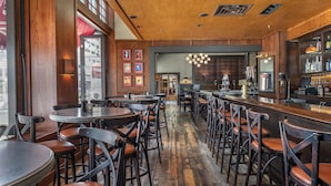 A restaurant with wooden floors, bar area, and multiple tables and chairs. - Best Western Plus The Normandy Inn & Suites (Minneapolis)