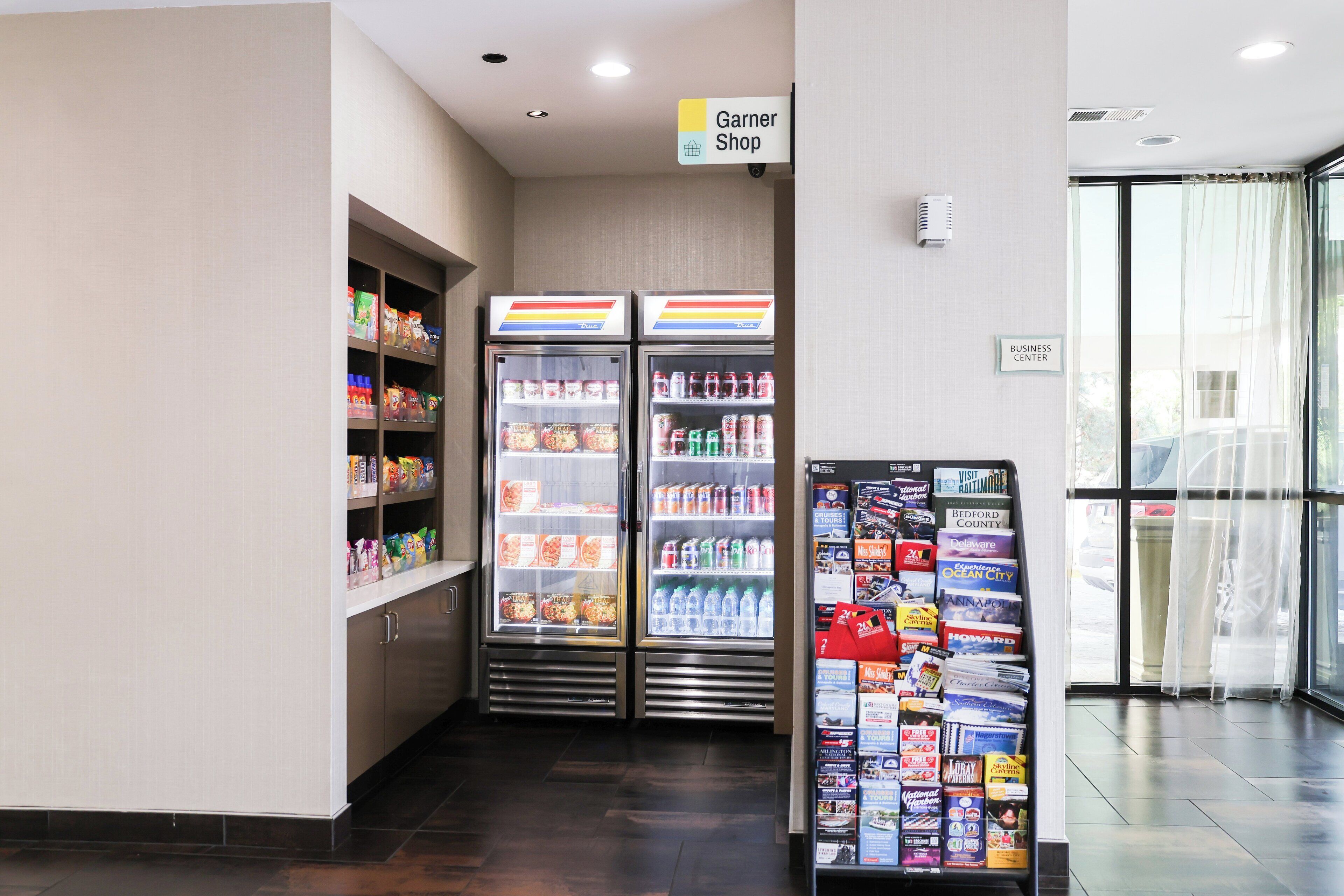 Zona de alimentación con congelador, sección refrigerada y un mostrador de revistas.