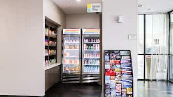 Zona de alimentación con congelador, sección refrigerada y un mostrador de revistas.