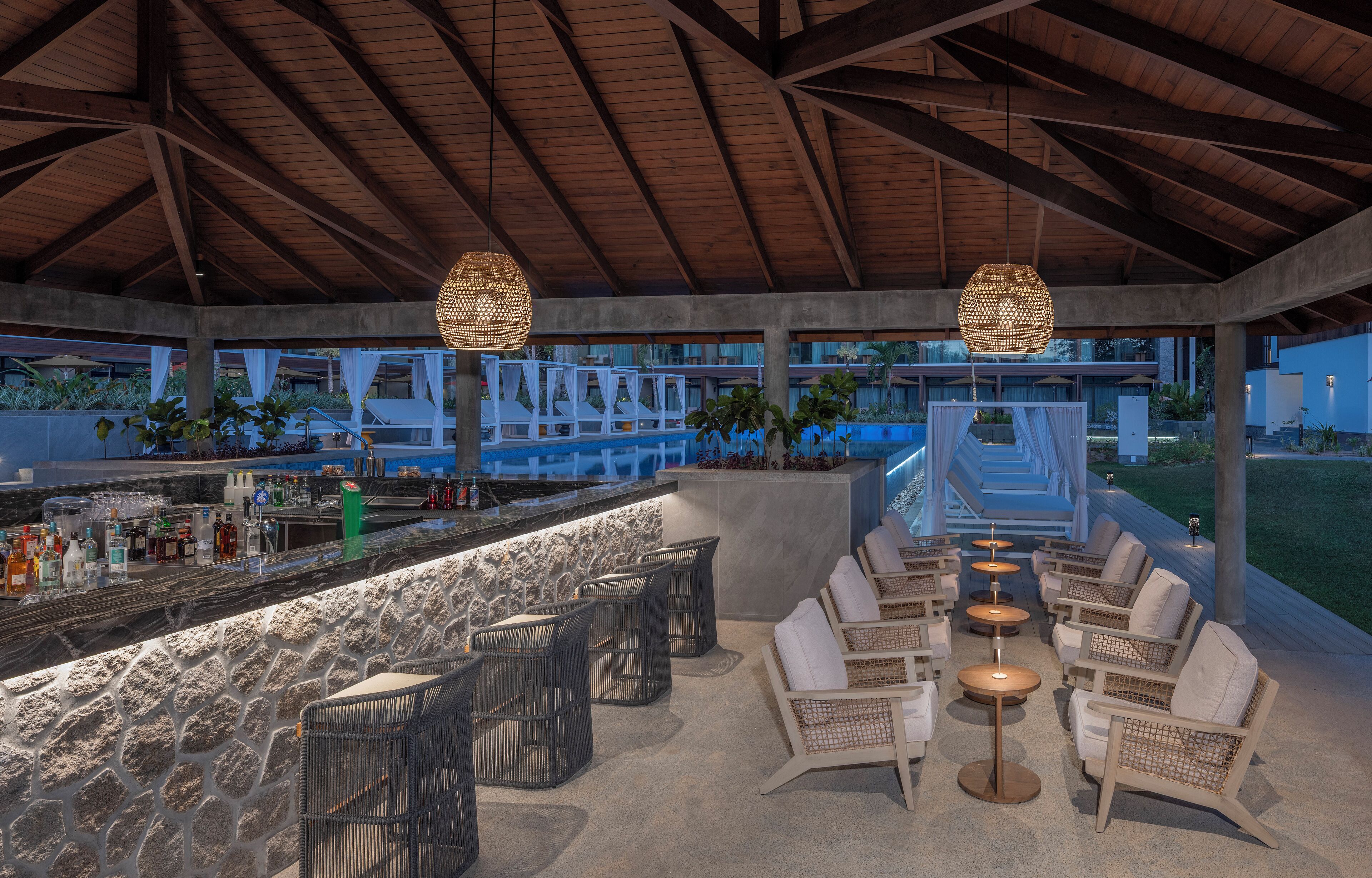 An outdoor bar area with seating and a pool view.