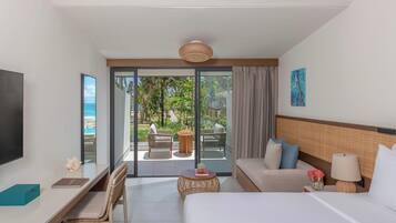A hotel room with a bed, a desk, a chair, a TV, a window, and a view of the outdoor area.