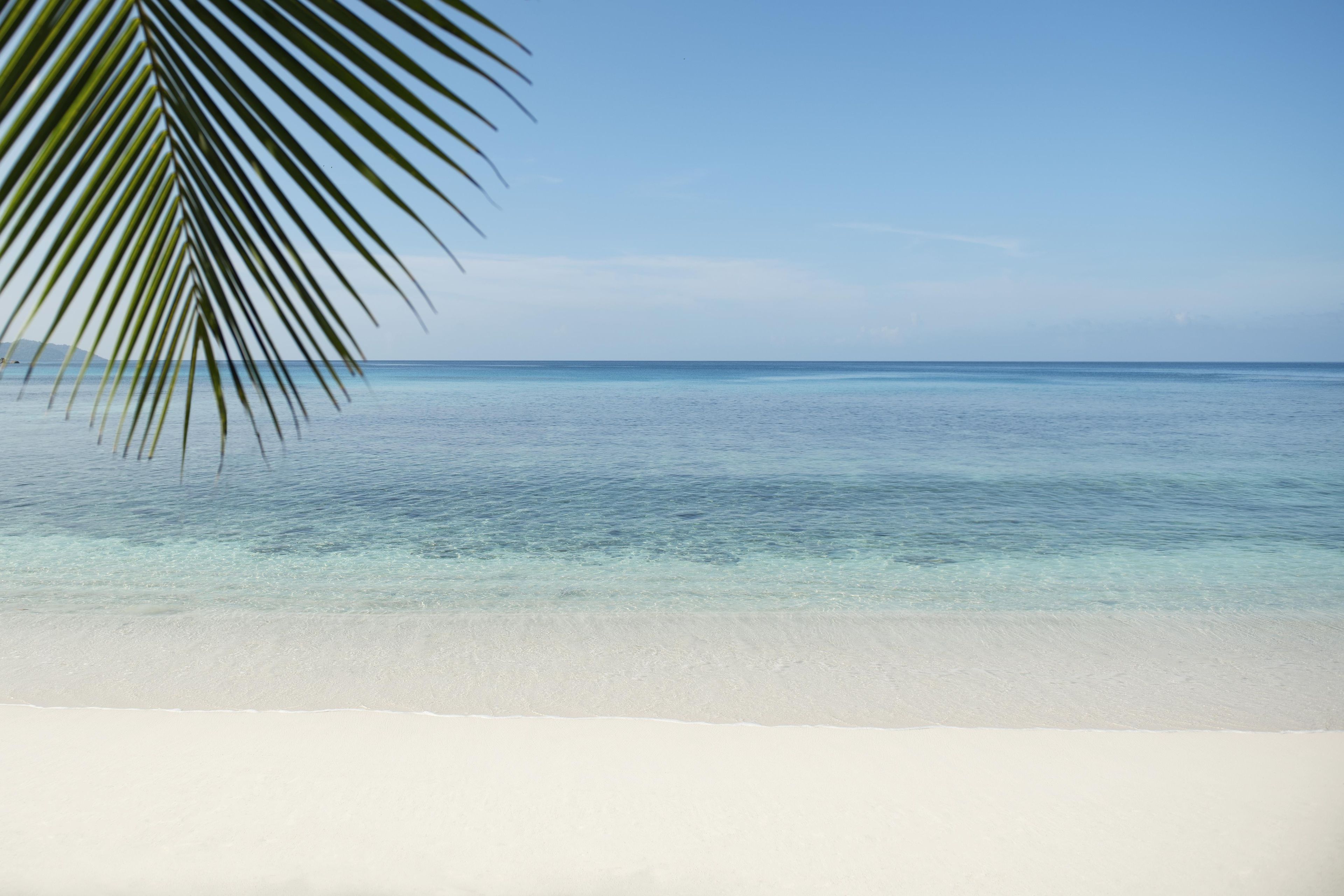 A beach with clear turquoise water and white sand.