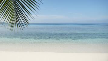 A beach with clear turquoise water and white sand.