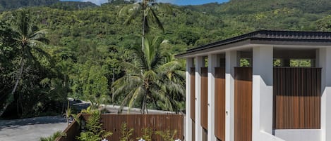 Un resort con piscina, palmeras y vistas a una cadena montañosa.