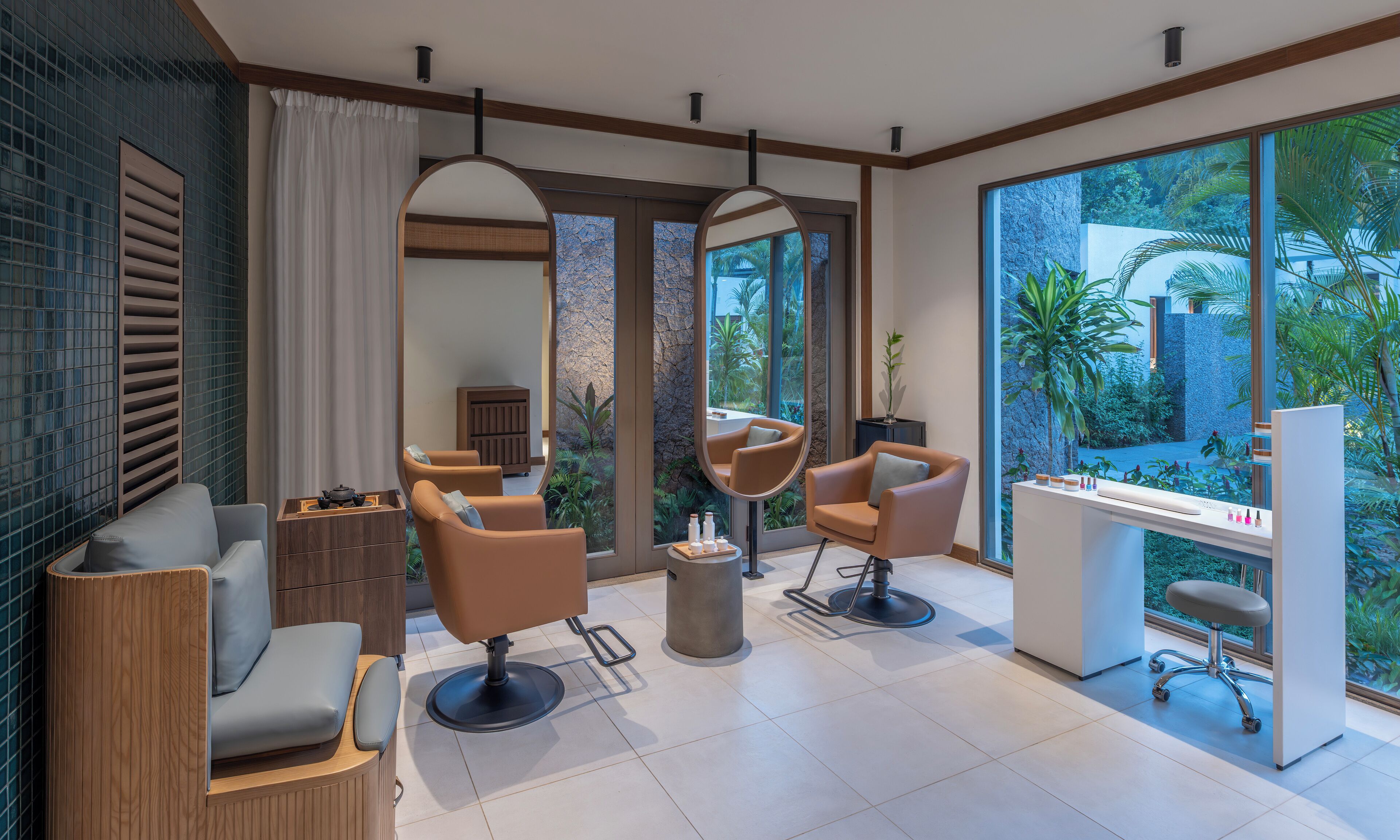 Ein modernes Salon-Interieur mit großen Fenstern, einer Rezeption und mehreren Sitzbereichen.